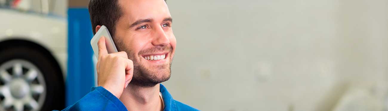 Kfz-Mechaniker telefoniert mit dem Handy